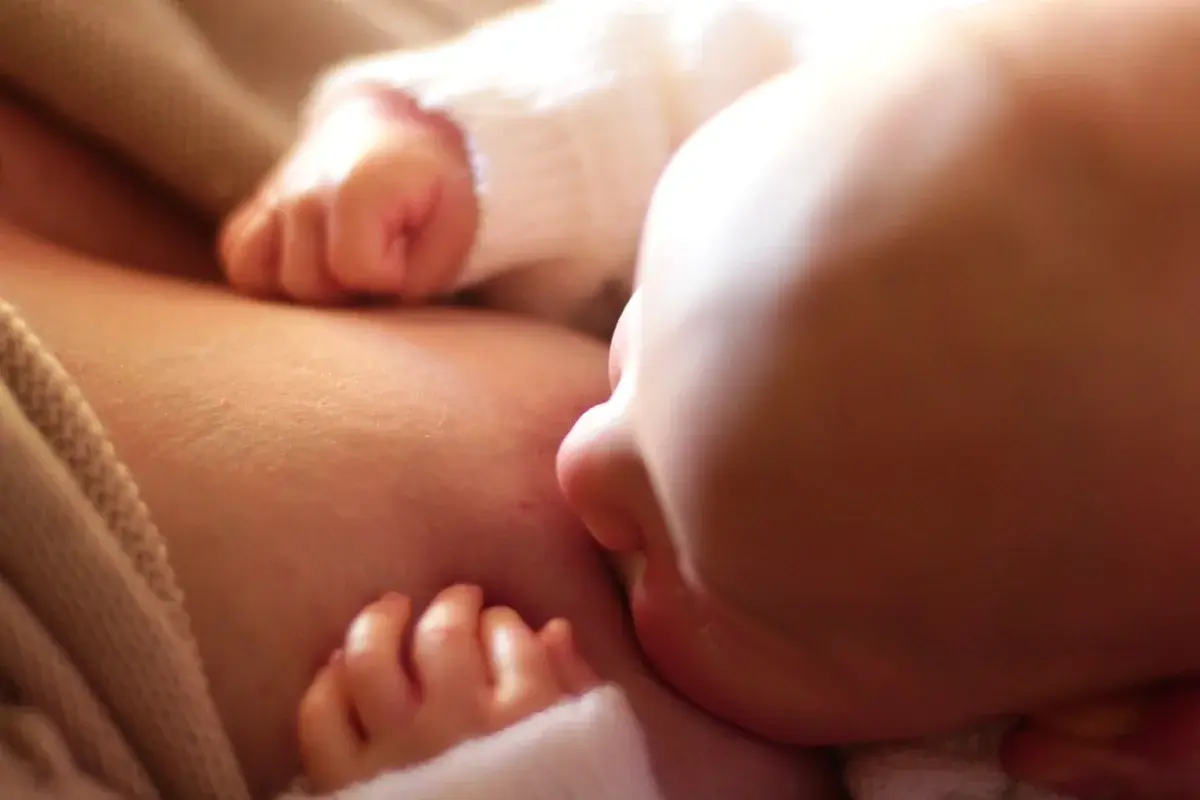 Close-up of a newborn baby breastfeeding.